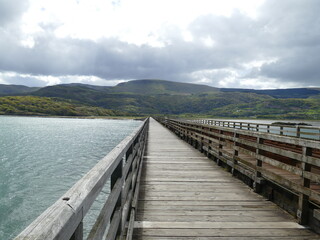 Wooden Barmouth Bridge across the Mawddach Estuary with mountains in the background