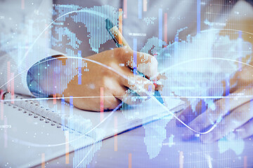 Double exposure of Man writing in notepad with business icons on background.