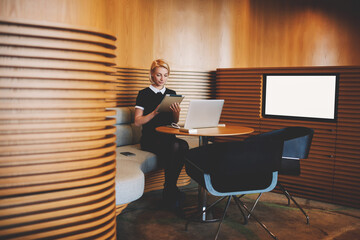 Young confident business owner is checking e-mail on digital tablet, while is waiting file download...