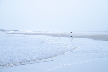 海で裸足で遊ぶ母子