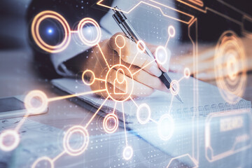 Social network theme hologram over hands taking notes background. Concept of global international people connect. Double exposure