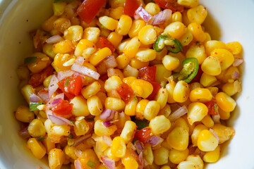 Spicy boiled corn salad. Chatpata sweet corn snacks prepared with tomatoes, onions and spices.
