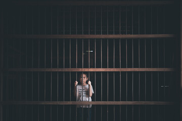 Asian little boy arrested in old and dark prison with concept
