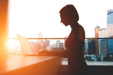 Double exposure silhouette of businesswoman is working in office with net-book while sitting at desktop. Hipster girl internet user of laptop computer is connecting to 5th generation wireless system