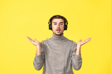 single man on yellow background listening music