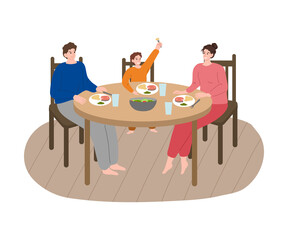 Young family with son enjoying dinner with salmon and salad together