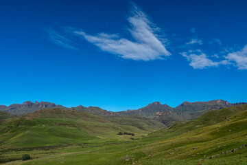 Thin wind spread cloud against the blue sky over the mountain