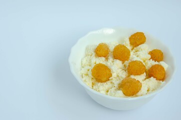 Cheese in a white plate and yellow raspberries. Raspberries and cottage cheese