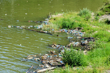 Obraz na płótnie Canvas Plastic and trash pollution on Bicaz lake, Romania. Trash in the mountain lake.