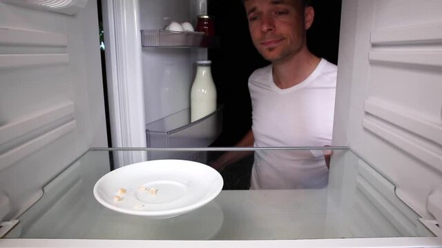 Man looking inside an empty fridge