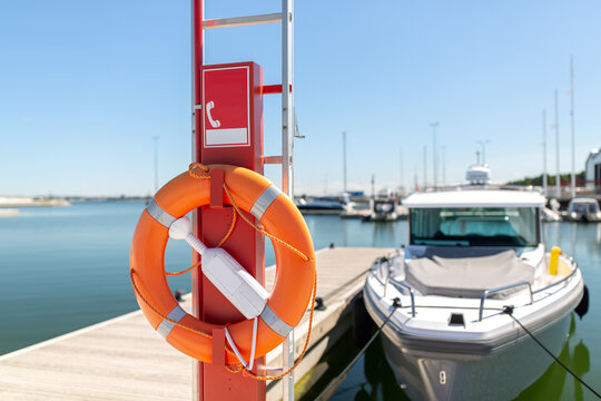 safety and rescue equipment concept - life ring or lifebuoy hanging on post at sea berth