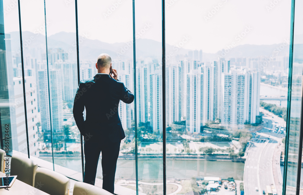 Poster back view of male entrepreneur in formal wear talking via smartphone device about results of ssucces