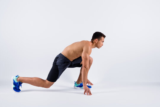 Ready steady go. Full body profile photo of handsome sportsman dark skin guy naked chest run sprint workout exercise stand on start line wear shorts sneakers isolated white color background
