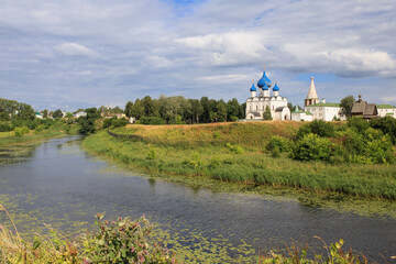 Fototapeta premium Landscape with a river and trees against the background of the Suzdal Kremlin, Russia.