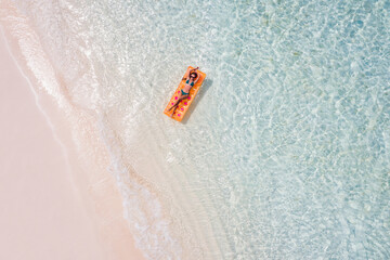 Top above high angle aerial drone view of fit slim slender thin attractive girl floating lying on rubber mattress clean clear pure sea water enjoy joy relax paradise hot destination good sunny weather