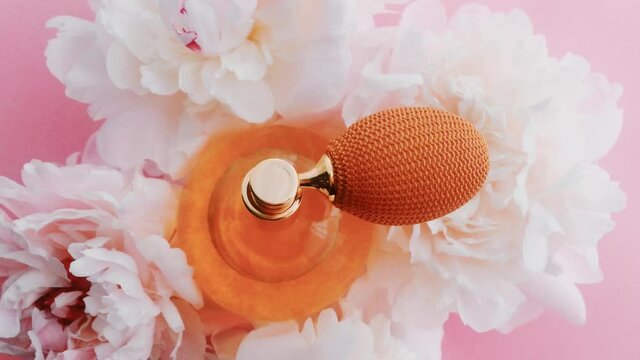 Citrus perfume bottle with peony flowers, chic fragrance scent as luxury cosmetic, fashion and beauty product background, stock footage