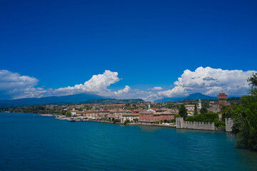Naklejka na ściany i meble Lazise, Lake Garda, Italy. Aerial view of the historic city of Lazise, in the background cumulus clouds on a blue sky