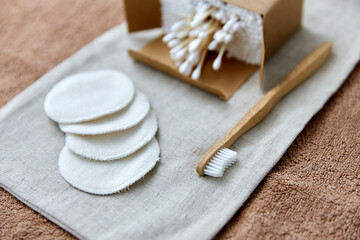 natural cosmetics, sustainability and eco living concept - wooden toothbrush, cotton pads and swabs...