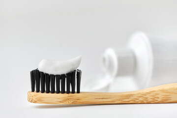 dental care, sustainability and eco living concept - close up of wooden toothbrush with white...