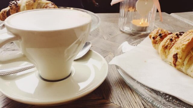 Cappuccino and chocolate croissant in cafe, cup of coffee and pastry dessert for breakfast, food and baked goods close-up