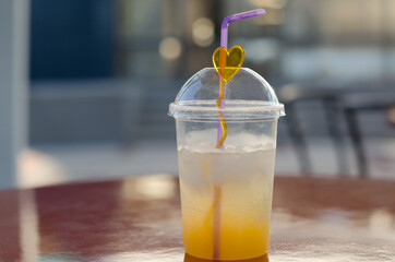Lemonade on the table in a plastic glass close-up. Summer refreshments.