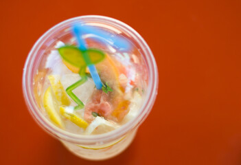 A glass of lemonade on an orange background. Selective focus.