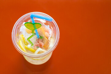 A glass of lemonade on an orange background. Selective focus.