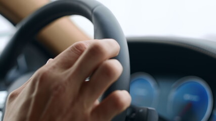 Male hand knocking fingers on steering wheel. Man putting fingers on wheel