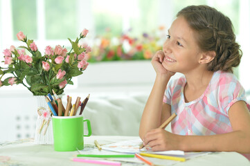 Portrait of cute girl drawing picture at home