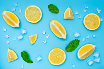 Lemon set with ice cubes and mint leaves on blue background. Different slices of lemon top view. Mojito or lemonade ingredients. 