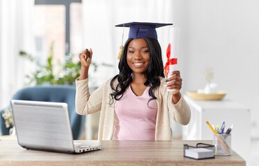 e-learning, education and people concept - happy smiling african american female graduate student...