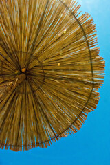 Umbrella wood on blu sky. Ocean beach. Close-up