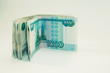 One thousand rubles banknotes are stacked on a white background