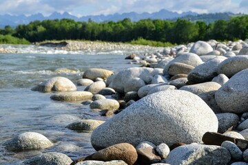 Fototapeta na wymiar Huge stones on the river bank. View of Bialka mountain river running through southern Poland. It is a tributary of the Dunajec River. Bialka river near Bialka Tatrzanska village, Poland, Europe