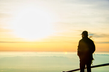 Obraz premium A man Clouds covering valleys in the morning mist on the high mountains at Phu Thap Boek , Phetchabun Province,Thailand 