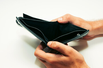 man holding an empty black wallet without money