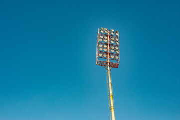 Floodlights with a metal pole for the sports arena. Tall high outdoor stadium spotlights on rigid...