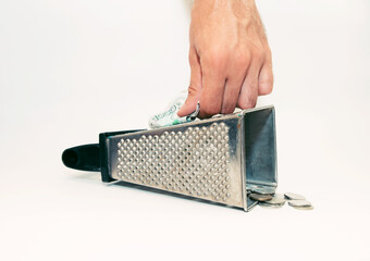 a man’s hand rubs a banknote, and iron coins lie below