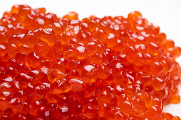Red caviar isolated on a white background. Gourmet food close up. Macro shot, shallow depth of field
