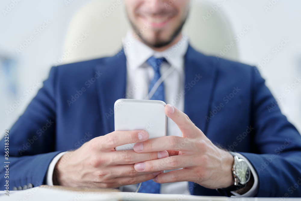 Poster Close-up of businessman in suit using smartphone while texting message to colleague
