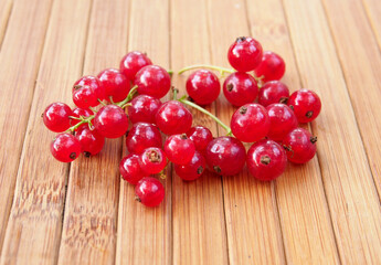 Ripe clusters of red currant berries on a wooden surface