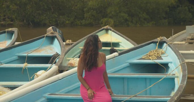 Sexy model sitting on a fishing boat enjoying the scenery on the Caribbean island of Trinidad