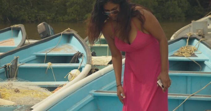 A sexy model walks out a fishing boat with her hair blowing in the wind