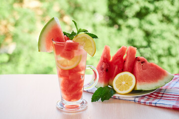 Summer refreshing drink with ice, slices of watermelon, lemon.
