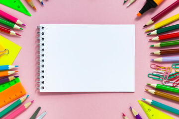 Fototapeta premium School colorful supplies and paper note on pink, flat lay, top view, back to school, copy space, mockup