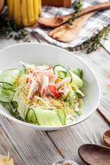 Salad with sliced cucumber ground eggs and crab
