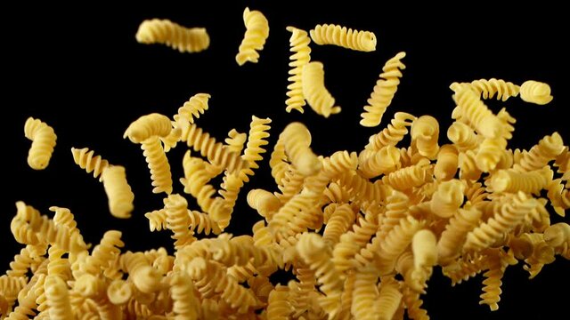 Super slow motion of flying uncooked italian pasta torti on black background. Filmed on high speed cinema camera, 1000 fps.