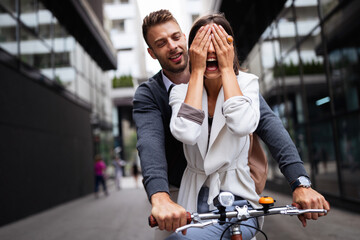 Portrait of happy young couple riding a bike and having fun together outdoor