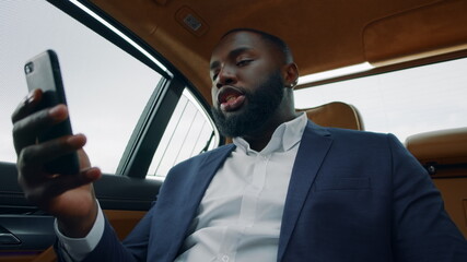 Closeup african man having video call at car. Business man talking phone at car
