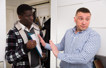 Indignant man refusing to debt payment to debt collector who visited him at home